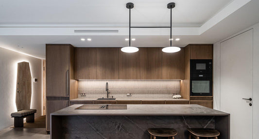 A kitchen with under-cabinet task lighting and ambient ceiling lights.